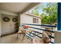 Cozy balcony with blue railing, table and chairs, plants, and views of the surrounding trees at 1000 Winderley Pl # 237, Maitland, FL 32751