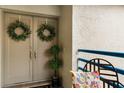 Inviting entryway with double doors, greenery wreaths, a small potted plant, and neutral colors at 1000 Winderley Pl # 237, Maitland, FL 32751