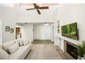 Bright living room with vaulted ceilings, a fireplace, built-in shelving, and neutral decor at 1000 Winderley Pl # 237, Maitland, FL 32751