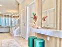 Inviting foyer features tiled floor, stylish decor, a wood-accent wall with a mirror, and comfortable green stools at 10012 Voyager Way, Orlando, FL 32821