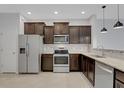 Kitchen area showcases stainless steel appliances, dark wood cabinets, and tile flooring at 1117 Pavia Dr, Apopka, FL 32703