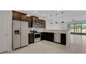 Modern kitchen featuring stainless steel appliances, dark cabinets and an open concept at 1117 Pavia Dr, Apopka, FL 32703