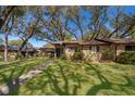 Inviting brick townhouse with lush green lawn and mature trees at 1735 Foxhall Cir # 1735, Kissimmee, FL 34741