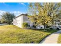 Spacious home with a well-kept lawn, mature trees, and a neatly trimmed garden at 1865 Sanderling Dr, Clermont, FL 34711