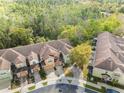 An aerial view of a colorful multi-unit residential complex surrounded by lush green trees and landscaping at 2015 Shalimar Loop, Sanford, FL 32773