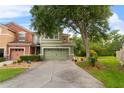 A green two-story townhouse with a two-car garage and mature landscaping at 2015 Shalimar Loop, Sanford, FL 32773
