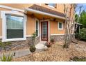 Charming front entrance with stone accents, red front door, and decorative landscaping at 2015 Shalimar Loop, Sanford, FL 32773