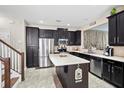 Modern kitchen with stainless steel appliances, an island, and dark cabinetry at 2015 Shalimar Loop, Sanford, FL 32773