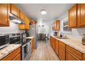 Well-lit kitchen with stainless steel appliances, stone countertops and plenty of wooden cabinetry at 2437 S Cedar Ave, Sanford, FL 32771