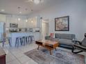 Open-concept living room seamlessly connected to a modern kitchen with bar stool seating at 500 E Crystal Lake St, Orlando, FL 32806