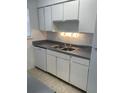 Functional kitchen design with white cabinets, countertops, and a sink at 5317 Curry Ford Rd # Q104, Orlando, FL 32812