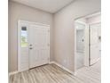 Bright foyer with light wood-look floors, white trim and a front door with sidelight at 5996 Wildflower Field Way, St Cloud, FL 34771