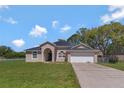 Inviting single-story home with attached two-car garage, well-maintained landscaping, and a classic architectural design at 68 Herring Ct, Kissimmee, FL 34759