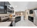 Well-lit kitchen showcasing modern appliances, dark cabinetry, tile floors, and ample counter space at 68 Herring Ct, Kissimmee, FL 34759