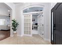 Spacious foyer showcasing French doors, black front door, and arched doorway at 8176 Emerald Forest Ct, Sanford, FL 32771