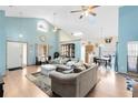 Open-concept living room with vaulted ceilings, ceiling fans and light blue paint at 835 Longleaf Pine Ct, Orlando, FL 32825