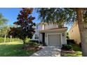 Charming home featuring a two-car garage, lush green lawn and garden, with tidy landscaping at 8991 Cuban Palm Rd, Kissimmee, FL 34747