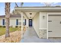 Welcoming front entrance with stone accents, a covered porch, and a stylish blue door at 96 Pecan Dr, Ocala, FL 34472