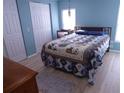 Cozy bedroom with wood-look floors, bright blue walls, and ample closet space at 361 Wade Park Ct, Davenport, FL 33897