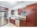 Modern kitchen featuring stainless steel appliances, farmhouse sink, dark wood cabinets, and a stylish backsplash at 1205 Flewelling Ave, Ocoee, FL 34761