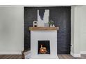 Close-up of a modern fireplace with a brick surround, wooden mantel, and a cozy fire burning at 1240 Moton Ave, Sanford, FL 32771