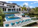 Resort-style pool area with tanning chairs, tiered pools, cascading water feature, and backyard basketball court at 1297 Grand Traverse Pkwy, Reunion, FL 34747