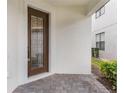 Close up of the front door with decorative glass, brick patio, and stucco exterior at 1344 Blue Stem Lane, Winter Park, FL 32792