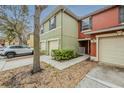 Exterior view of townhomes displaying attached garages, small bushes, and a sidewalk entryway at 13441 Starry Night Ct # 9, Orlando, FL 32824