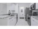 Well-lit kitchen featuring stainless steel appliances, granite countertops, white cabinets, and tile flooring at 14205 Falls Church Dr # 2001, Orlando, FL 32837