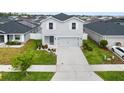 Charming two-story home with light gray siding, landscaped yard, and a two-car garage at 207 Polermo Ave, St Cloud, FL 34771