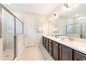 Elegant bathroom featuring a glass enclosed shower and double vanity with framed mirrors and great lighting at 273 Auburn Ave, Kissimmee, FL 34747