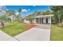 A single-story home features a driveway, carport, and a well-manicured front lawn with palm trees at 3107 Martinique Way, Orlando, FL 32805