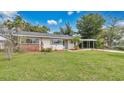 Inviting single-story home with fresh landscaping, lush green lawn, and convenient carport at 3107 Martinique Way, Orlando, FL 32805