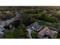 An aerial view showcasing the house nestled within a lush green neighborhood with mature trees at 3334 Park Grove Ct, Longwood, FL 32779