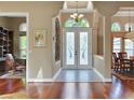 Elegant foyer with frosted double doors, chandelier lighting, and hardwood flooring at 3334 Park Grove Ct, Longwood, FL 32779