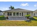 Back exterior view featuring a patio with a lush green lawn at 346 Vista Oaks Way, Davenport, FL 33837