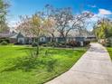 Charming single story home featuring well-manicured lawn, mature trees, and a traditional-style porch at 418 Norwood Ct, Oviedo, FL 32765