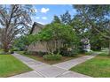 Beautiful home nestled among mature trees with a well-maintained lawn and crosswalk at 421 Broadway Ave, Orlando, FL 32803