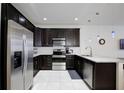 Kitchen featuring stainless steel appliances, dark cabinets, and granite countertops at 5025 Walker St, St Cloud, FL 34771