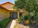 Inviting front entrance with a blue double door, a tiled roof, and lush landscaping around the walkway at 6552 Edgeworth Dr, Orlando, FL 32819