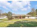 Inviting single-story home featuring well-maintained lawn, mature trees, and a welcoming entrance with red doors at 6762 Tamarind Cir, Orlando, FL 32819