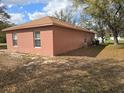 Exterior view of a single-story home featuring mature trees and a spacious yard at 721 Waxwing Ct, Kissimmee, FL 34759