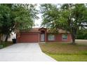 Charming single-story home featuring a two-car garage and a well-maintained front yard at 721 Waxwing Ct, Kissimmee, FL 34759