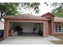 Exterior view of a single-story home with an open garage filled with boxes and household items at 721 Waxwing Ct, Kissimmee, FL 34759
