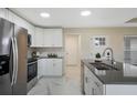 Well lit kitchen features modern stainless steel appliances, with an island and quartz countertop at 803 Marquis Ct, Kissimmee, FL 34759