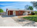 Single-story home with covered parking, red brick accents and mature landscaping at 1109 Denton Rd, Winter Park, FL 32792