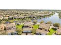 An aerial view showcases the community, with a lake view, and homes with well-maintained lawns at 12016 Lorenza Ln, Orlando, FL 32827