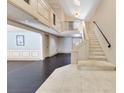 An open foyer features tile and wood flooring, decorative trim and a staircase to the second floor at 1213 Richmond Rd, Winter Park, FL 32789