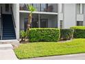 Condo exterior with a stairwell and manicured landscaping, showing a ground floor screened in patio at 1317 S Pine Ridge Cir # 1317, Sanford, FL 32773