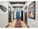 Bright foyer with wood-look floors, exposed beams, and a large blue door at 1412 Moon Valley Dr, Davenport, FL 33896